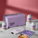 A product bundle display for GleeFull Supplements on a marble surface against a pink background. The layout includes a large purple shipping box featuring the slogan 'FEEL LIKE YOURSELF AGAIN.', three white bottles of Meno Burn Collagen, a purple branded pen, a matching notepad that reads 'REMINDERS WHEN I'M HAVING A MENOPAUSE MOMENT', and a recipe booklet titled 'THE MENOPAUSE Recipes'