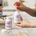 GleeFull Over 30 Hormone Support and Meno Joint Relief bottles on a marble countertop in a kitchen setting.
