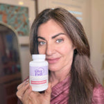 Woman holding a bottle of Glee Full supplement in an indoor setting